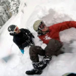 Snowboarder being rescued from snow