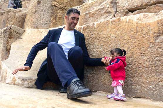 The world's tallest person and 2 feet women