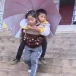 Mutual girl going to school to disabled brother taking on the back