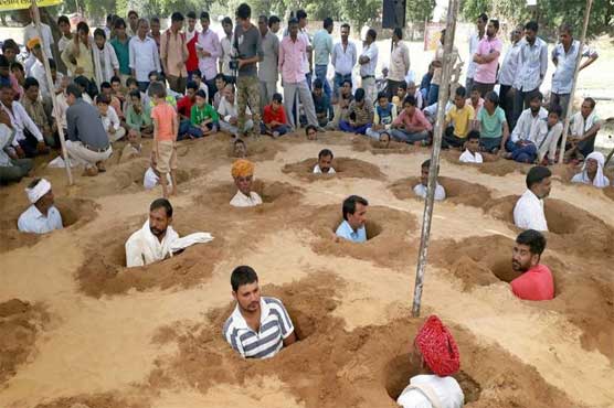 Indian farmers bury in the land against the occupation of the land
